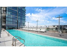 A pool area with a blue pool and white lounge chairs.