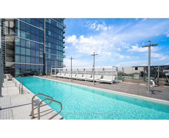 A pool area with a blue pool and white lounge chairs.