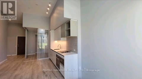 A modern kitchen with a glass door cabinet and a wooden floor.