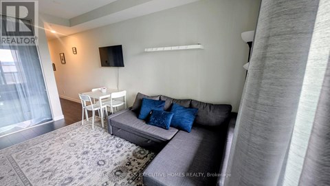 A living room with a grey couch and a white table.