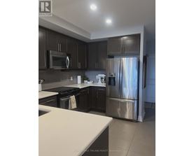 A kitchen with dark brown cabinets and stainless steel appliances.