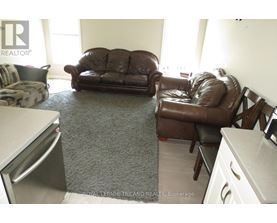 A brown leather couch and chair in a living room.