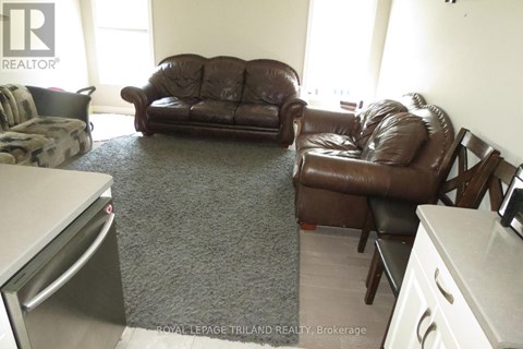 A brown leather couch and chair in a living room.