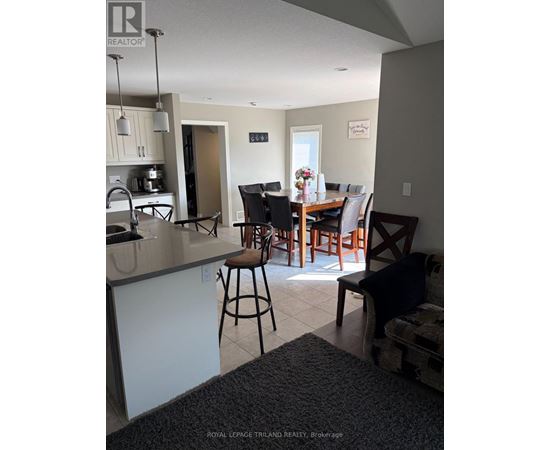 A kitchen with a bar stool and a dining table with chairs.