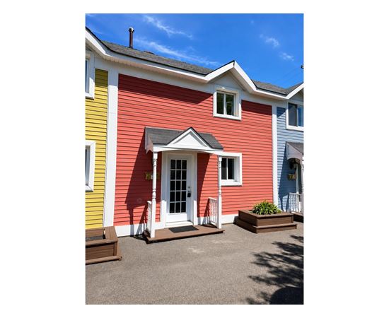 A red house with a white door and a small porch.