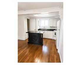 A black stove in a kitchen with wooden floors.