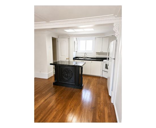 A black stove in a kitchen with wooden floors.