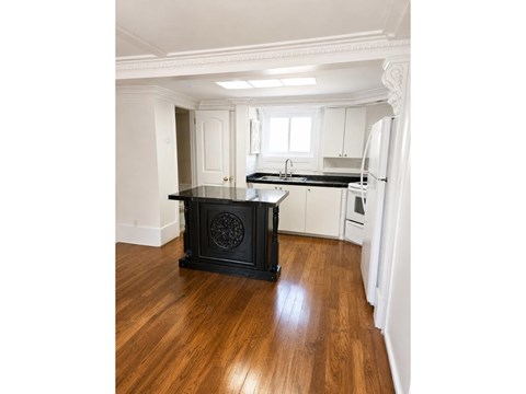 A black stove in a kitchen with wooden floors.