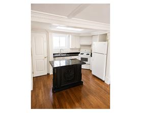 A black stove in a white kitchen.