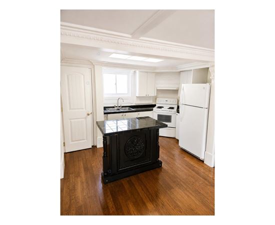 A black stove in a white kitchen.