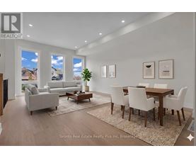 A well-lit, modern living room with a dining area and a view of the outdoors through the windows.