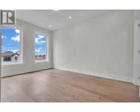 A room with a window showing a house and trees outside.