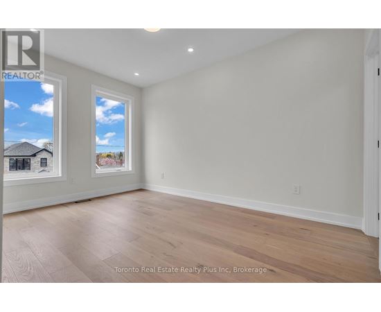 A room with a window showing a house and trees outside.