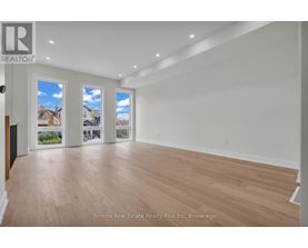 A spacious room with wooden flooring and white walls.