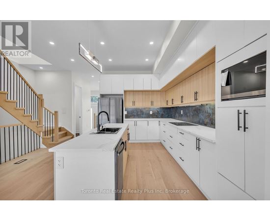 A modern kitchen with wooden cabinets and a staircase.
