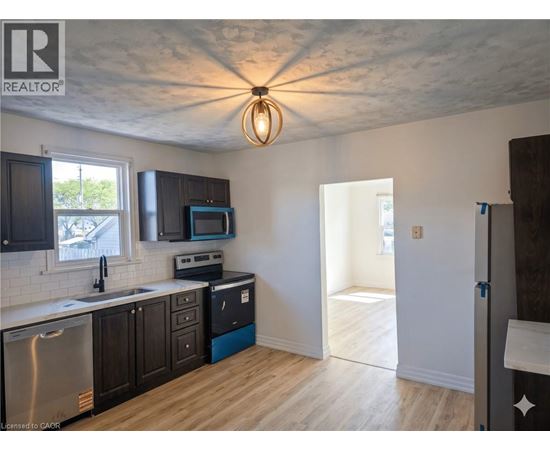 A kitchen with wooden floors and a ceiling fan.