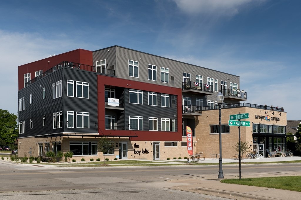 A multi-story building with a red and grey exterior and a sign that reads "The Boy Leys".