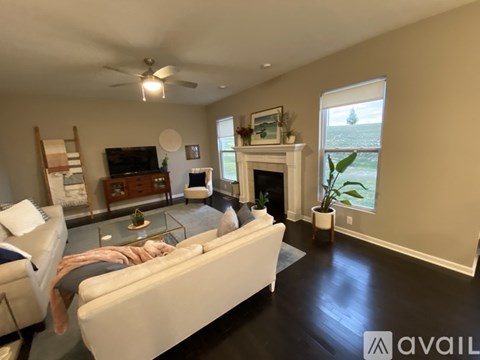 A living room with a white couch and a fireplace.