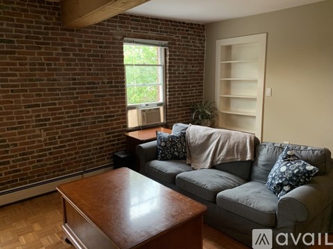 A living room with a grey couch and a wooden coffee table.