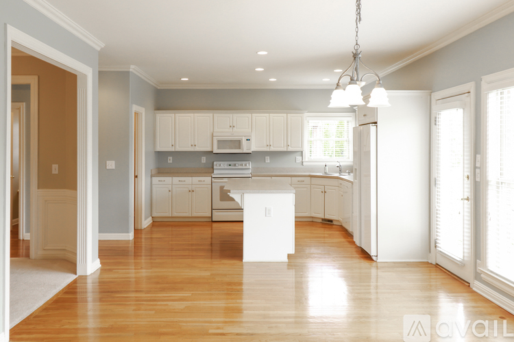 A kitchen with white cabinets and a white island.