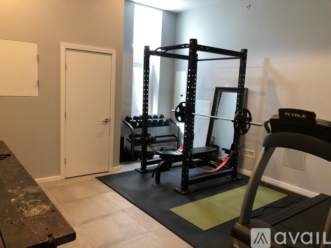 A home gym with a squat rack, bench, and weights.