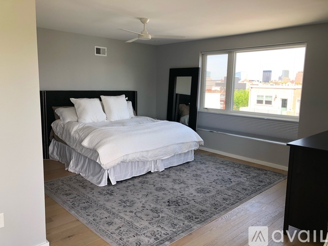 A bedroom with a large bed and a ceiling fan.