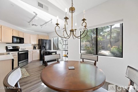 A modern kitchen with a wooden table and chairs.