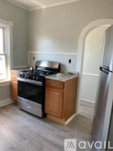 A kitchen with a stove, refrigerator, and cabinets.