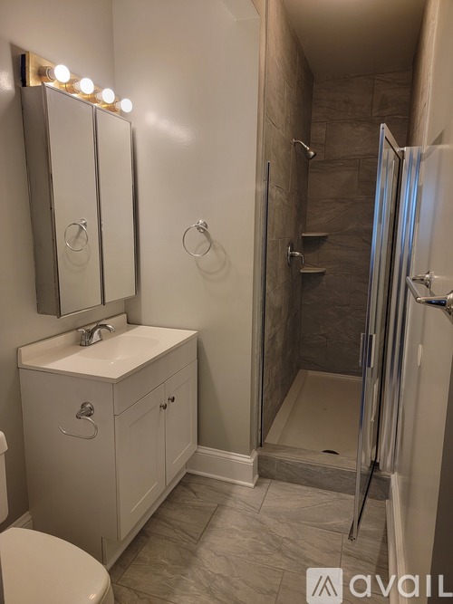 A bathroom with a toilet, sink, and shower.