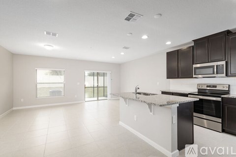 A kitchen with black cabinets and stainless steel appliances.