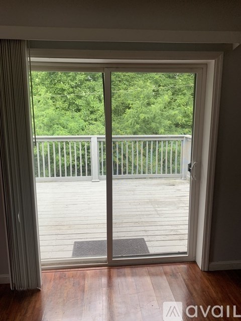 A balcony with a sliding glass door leading to a deck.