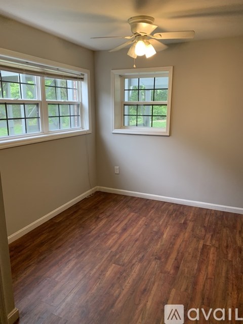 A room with wooden floors and a ceiling fan.