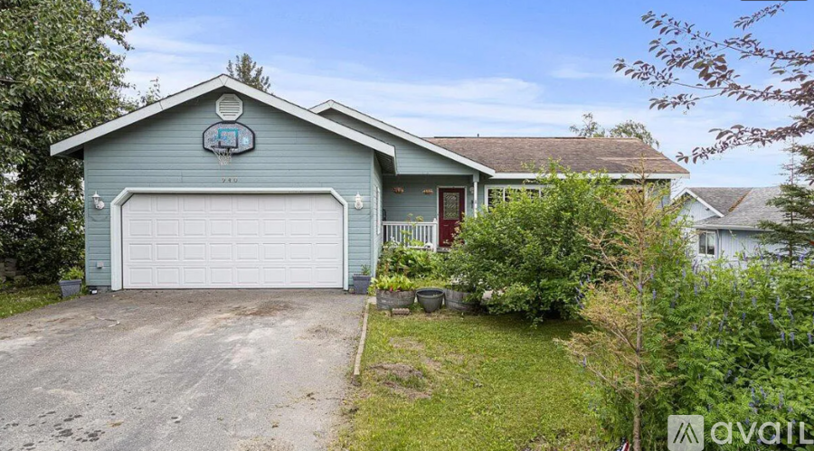 A blue house with a white garage door is for sale.