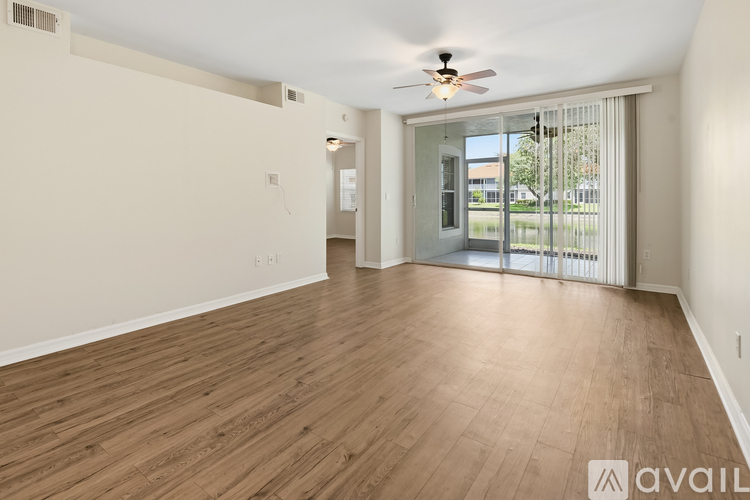 A spacious room with wooden flooring and a ceiling fan.