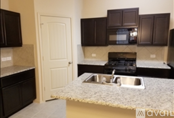A kitchen with a sink and a stove top.