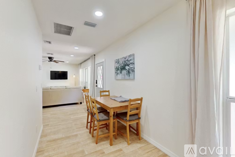 A dining room with a wooden table and chairs.