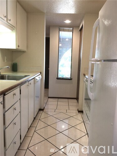 A kitchen with white appliances and white cabinets.