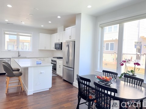 A kitchen with white cabinets and a wooden island.
