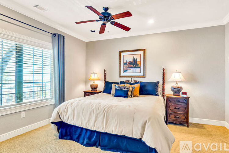 A bedroom with a large bed and a ceiling fan.