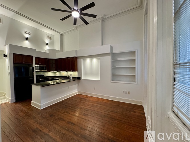 A kitchen with a ceiling fan and wooden floors.