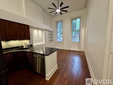 A kitchen with dark wood cabinets and a black countertop.