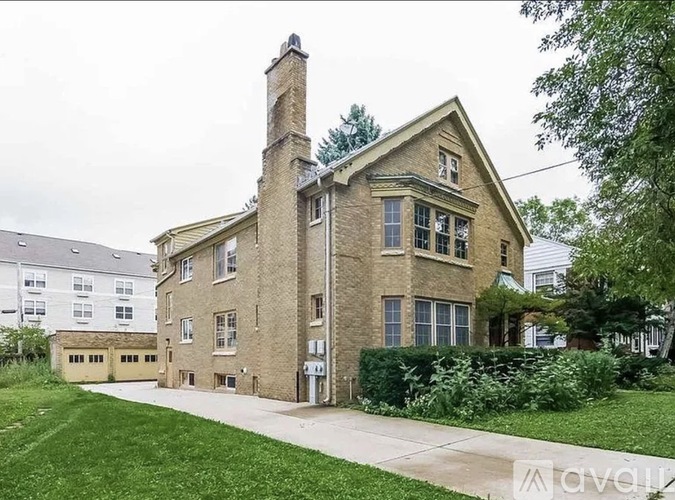 A large house with a chimney and a driveway.