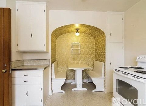 A kitchen with a white table and chairs and a white oven.