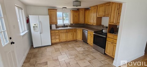 A kitchen with wooden cabinets and a white refrigerator.