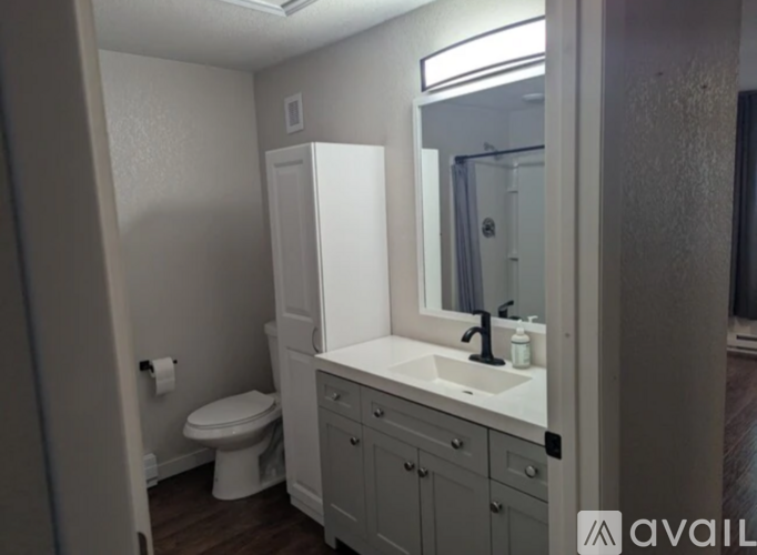 A bathroom with a toilet, sink, and medicine cabinet.