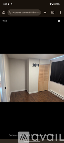 A bedroom with a bed and a window with blinds.