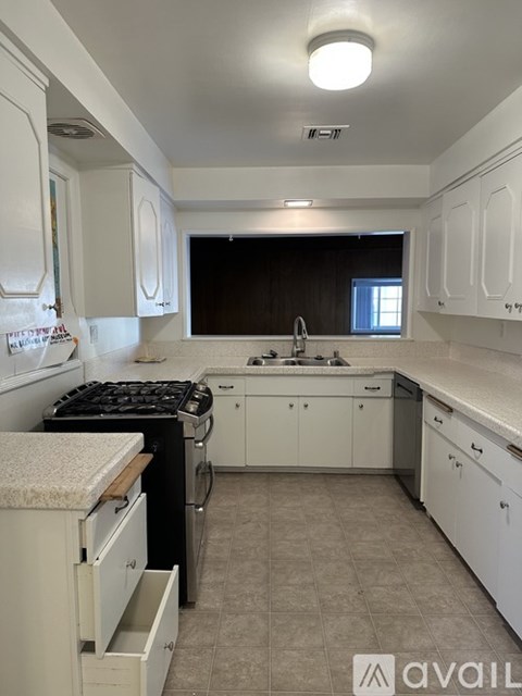 A kitchen with white cabinets and a black stove top.