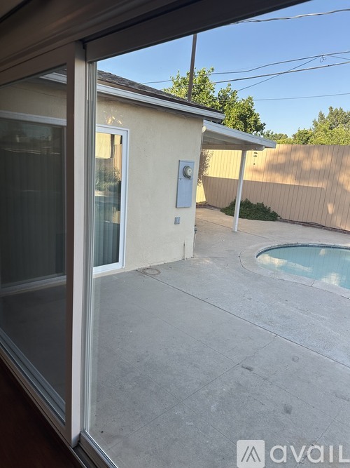 A patio with a pool and a sliding glass door.