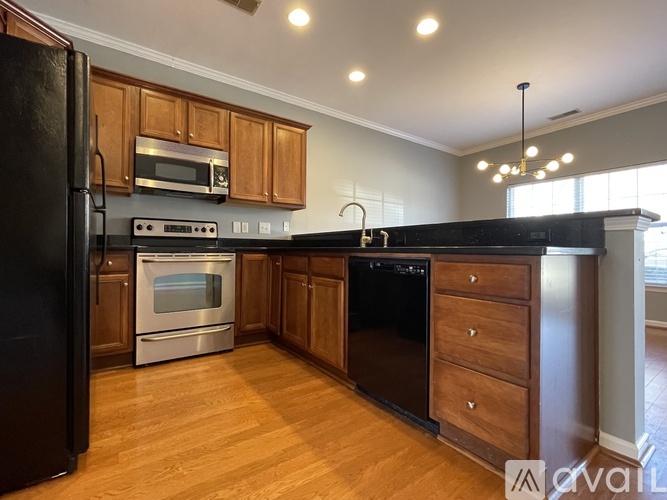 A kitchen with wooden cabinets and black appliances.