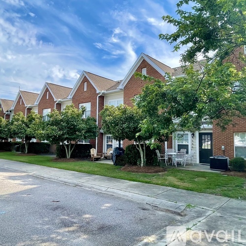 A row of houses with trees in front of them.